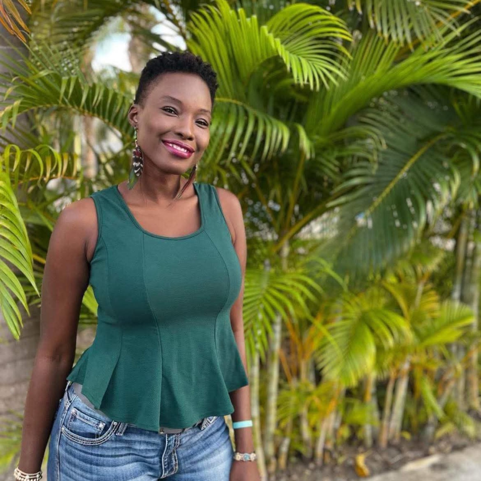 Aissata Sow standing before tropical greenery